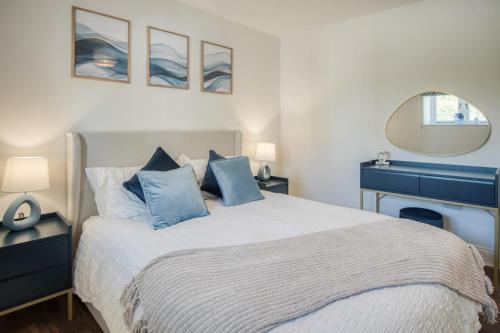 a bedroom with a large bed with blue pillows at The Studio - 1 Bedroom Cottage - Princes Gate in Ludchurch