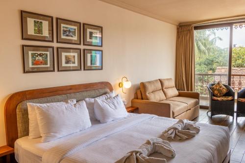 a bedroom with a bed and a chair and a window at Casa Peacock in Calangute