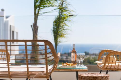 a table with a bottle of wine and a plate of food at Blue Hills Villa in Kallithea Rhodes