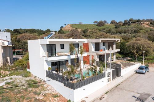 a white house with a balcony with plants at Blue Hills Villa in Kallithea Rhodes