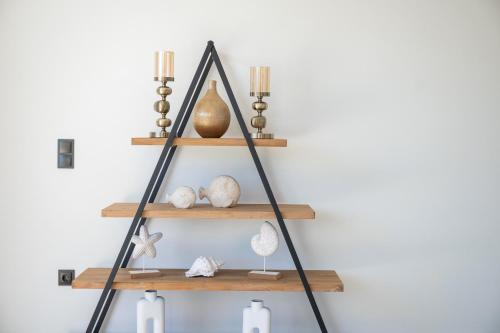a wooden shelf with shells and candles on a wall at Blue Hills Villa in Kallithea Rhodes