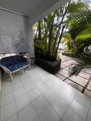 a patio with a bench and palm trees at Appartement Baobab 2 in Pereybere