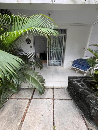 a porch with a blue bench and a chair at Appartement Baobab 2 in Pereybere