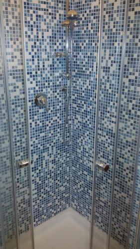 a bathroom with a shower with blue and white tiles at La Sosta di Braccio in Macchie