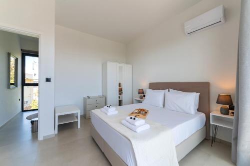 a bedroom with a white bed with towels on it at Blue Hills Villa in Kallithea Rhodes