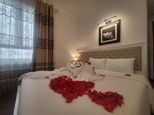 a bedroom with a bed with a bouquet of red roses at Luxor Boutique Hotel in Hanoi