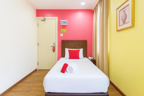 a bed in a room with a red wall at Hotel Sunjoy9 Bandar Sunway in Petaling Jaya