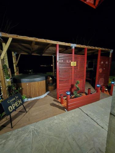 a red building with a wooden deck at night at La Casa Mora Grande in Asson