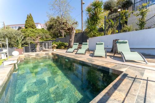 une piscine avec des chaises longues à côté d'un bâtiment dans l'établissement Magnifique appartement avec piscine et jardin, à Nice