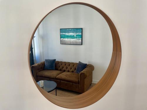un salon avec un canapé et un miroir dans l'établissement Charming Central Apartment - Reims, à Reims