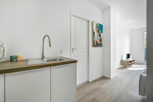 une cuisine avec des armoires blanches et un évier dans l'établissement Le CityNest - 4 pers - Parking - Wifi, à Évreux