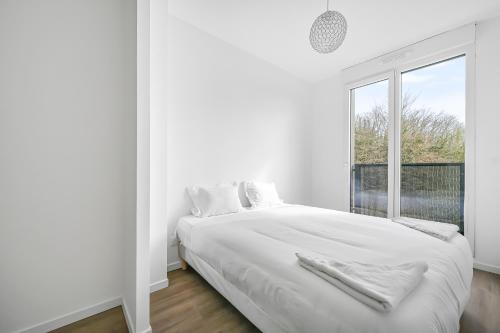 une chambre blanche avec un lit et une fenêtre dans l'établissement Le CityNest - 4 pers - Parking - Wifi, à Évreux
