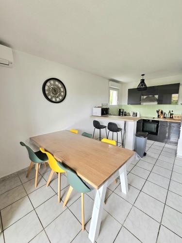 une cuisine et une salle à manger avec une table et des chaises en bois dans l'établissement Paisible appartement climatisé avec jardin, à La Teste-de-Buch