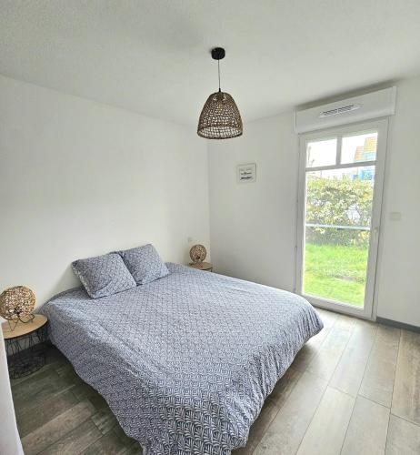 une chambre blanche avec un lit et une fenêtre dans l'établissement Paisible appartement climatisé avec jardin, à La Teste-de-Buch