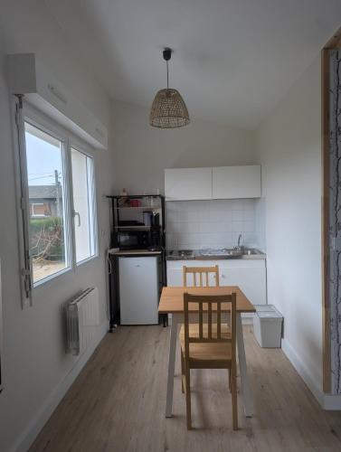 une cuisine avec une table et des chaises dans une pièce dans l'établissement Séjour bien-être, à Mayet-de-Montagne