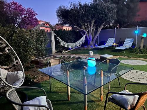 une table en verre avec des bâtons dans la cour dans l'établissement Coco Lodge Home, maison cosy entre mer et nature !, à Vic-la-Gardiole