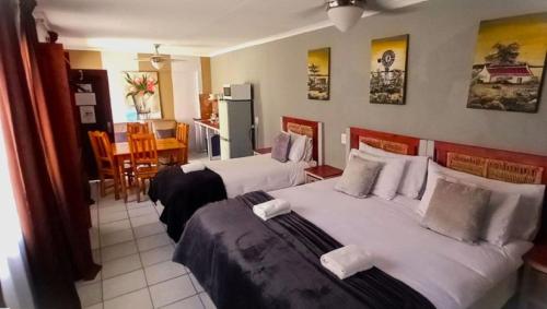 Una habitación de hotel con dos camas y cocina. en Edenville Guesthouse, en Lichtenburg