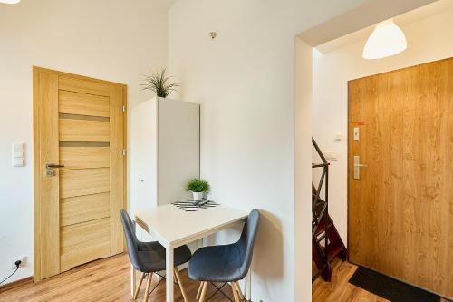 a small white table and chairs in a room with a door at Dworcowa 10D in Płock