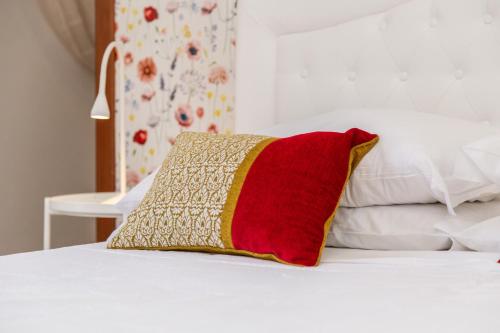 a red and yellow pillow sitting on top of a bed at B&B Calamoresca in Àrbatax