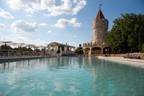 a pool of water with a building in the background at Sobor Family Resort in Stavcheny