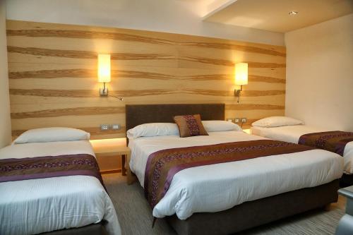 a hotel room with two beds and two lights at Hotel Garden in Peschiera del Garda