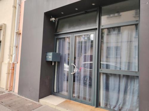 une porte en verre sur un bâtiment avec une fenêtre dans l'établissement CAEN le Port, à Caen