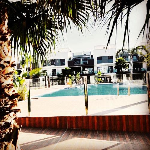 a swimming pool in front of a building at Casa Noyas Oasis Beach in Guardamar del Segura