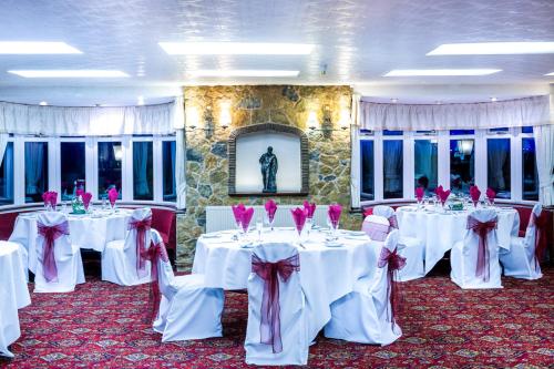 a banquet room with white tables with pink bows at The Down Inn in Bridgnorth