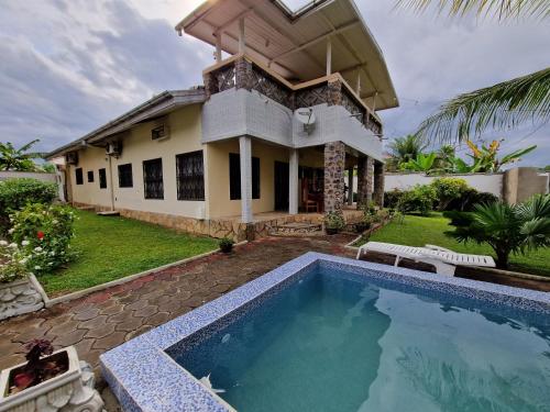 une maison avec une piscine devant une maison dans l'établissement Exclusive Beach Villa with Pool by Casa, à Kribi