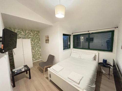 a small bedroom with a bed and a window at London E2 Rooms in London