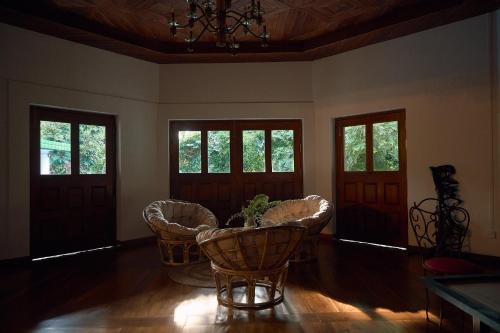 a living room with chairs and a table and windows at Kandahena Mansion in Akuressa