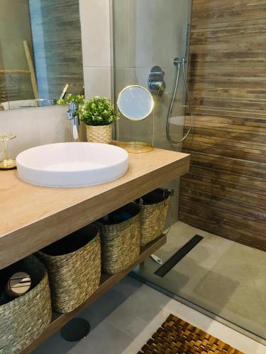 a bathroom with a sink and a mirror and a shower at Casa Noyas Oasis Beach in Guardamar del Segura