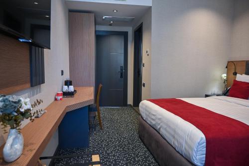 a hotel room with a bed and a desk at Landmark Hotel in Batumi