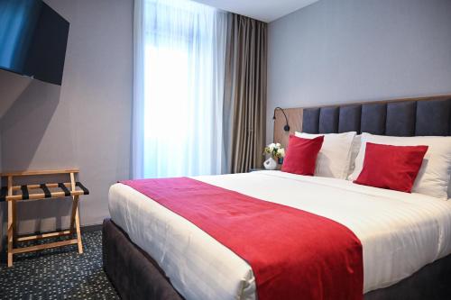 a hotel room with a large bed with red pillows at Landmark Hotel in Batumi