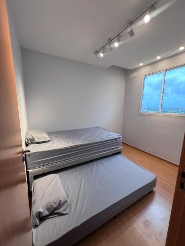 zwei Betten in einem Zimmer mit Fenster in der Unterkunft Castelão Apartment in Fortaleza