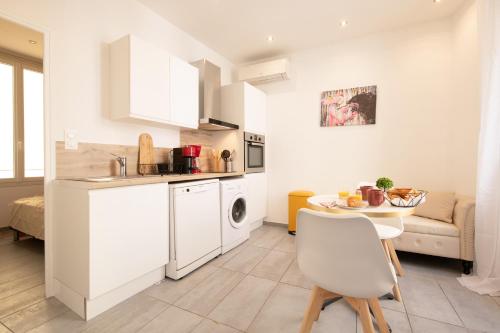 une cuisine et un salon avec un évier et une table dans l'établissement cœur historique de cannes entre palais et mer, à Cannes