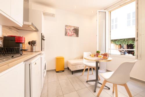 une cuisine et une salle à manger avec une table et des chaises dans l'établissement cœur historique de cannes entre palais et mer, à Cannes