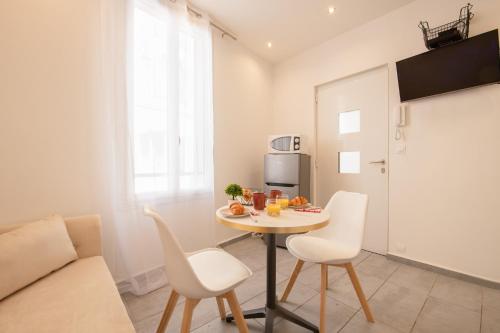 un petit appartement avec une table et des chaises dans une pièce dans l'établissement cœur historique de cannes entre palais et mer, à Cannes