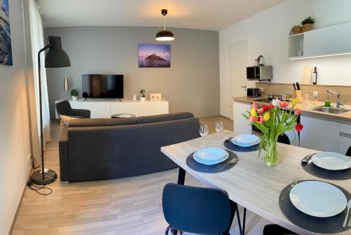 a kitchen and a living room with a table and chairs at Lakepark Residence in Staré Splavy