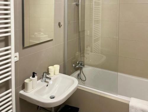 a white bathroom with a sink and a shower at Lakepark Residence in Staré Splavy
