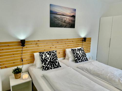 a bedroom with two beds and a wooden headboard at Lakepark Residence in Staré Splavy