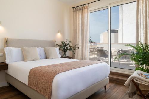 a bedroom with a large bed and a large window at Magno Apartments Altozano I in Seville