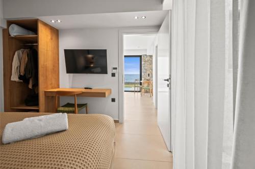 a bedroom with a bed and a view of the ocean at Evelmare Beachfront Apartments in Koutsourás