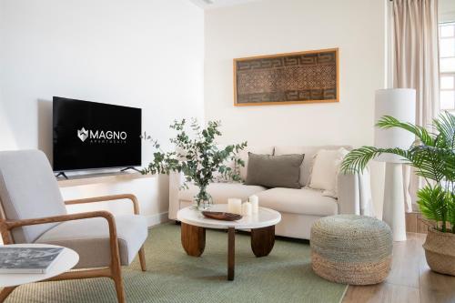 a living room with a couch and a tv at Magno Apartments Altozano I in Seville