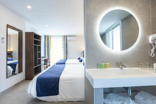a hotel room with a bed and a sink and a mirror at Hotel Internacional in Calella