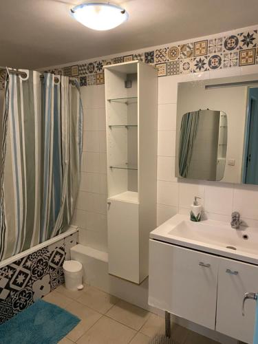 une salle de bain avec un lavabo, des toilettes et un miroir dans l'établissement Le beau soleil à Marseille, à Marseille