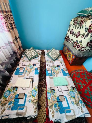 a bed with a quilt on it in a room at Oroz Guest House in Jangy-Talap