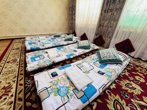 two beds sitting in a room with at Oroz Guest House in Jangy-Talap