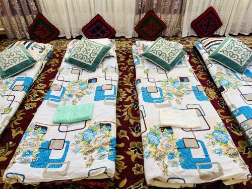 a bed with blue and white pillows on it at Oroz Guest House in Jangy-Talap