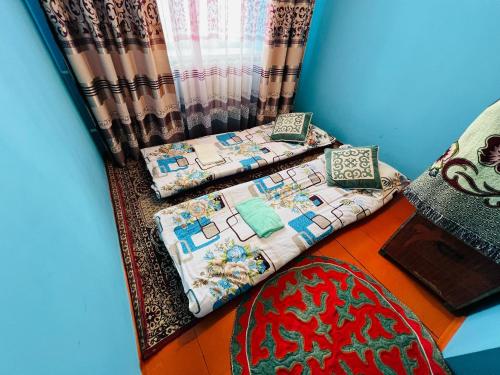 a room with two beds and a curtain at Oroz Guest House in Jangy-Talap